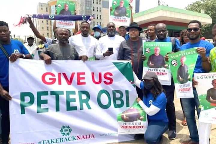 Members of the Obidients Movement display "Give Us Peter Obi" banner