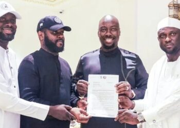 Obinna Iyiegbu, aka Obi Cubana, displays his appointment letter as the South-East Coordinator of the City Boy Movement