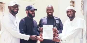 Obinna Iyiegbu, aka Obi Cubana, displays his appointment letter as the South-East Coordinator of the City Boy Movement