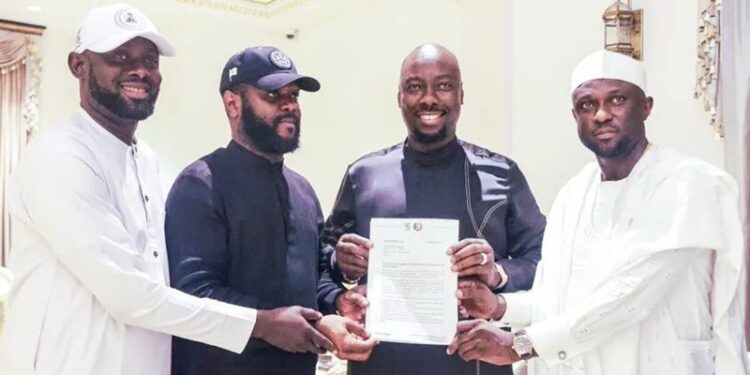 Obinna Iyiegbu, aka Obi Cubana, displays his appointment letter as the South-East Coordinator of the City Boy Movement